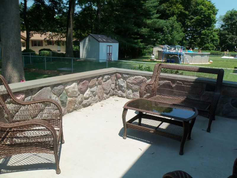 professional concrete patio with a stone wall