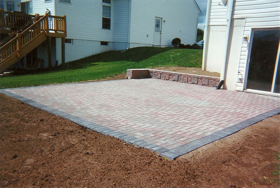square paver patio with red stone outlined by gray stone