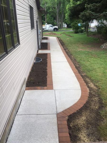 concrete sidewalk with brick boarder