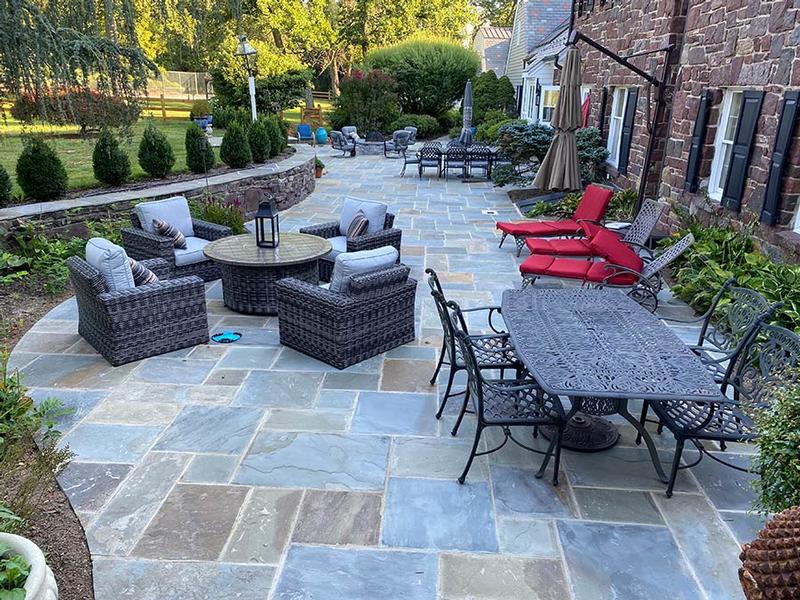 curved backyard hardscaped patio with outdoor furniture