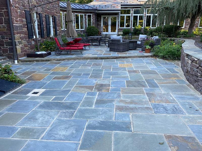 multi color hardscaped backyard patio with outdoor furniture