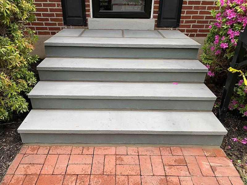 exterior stone steps leading to home with brick hardscape landing